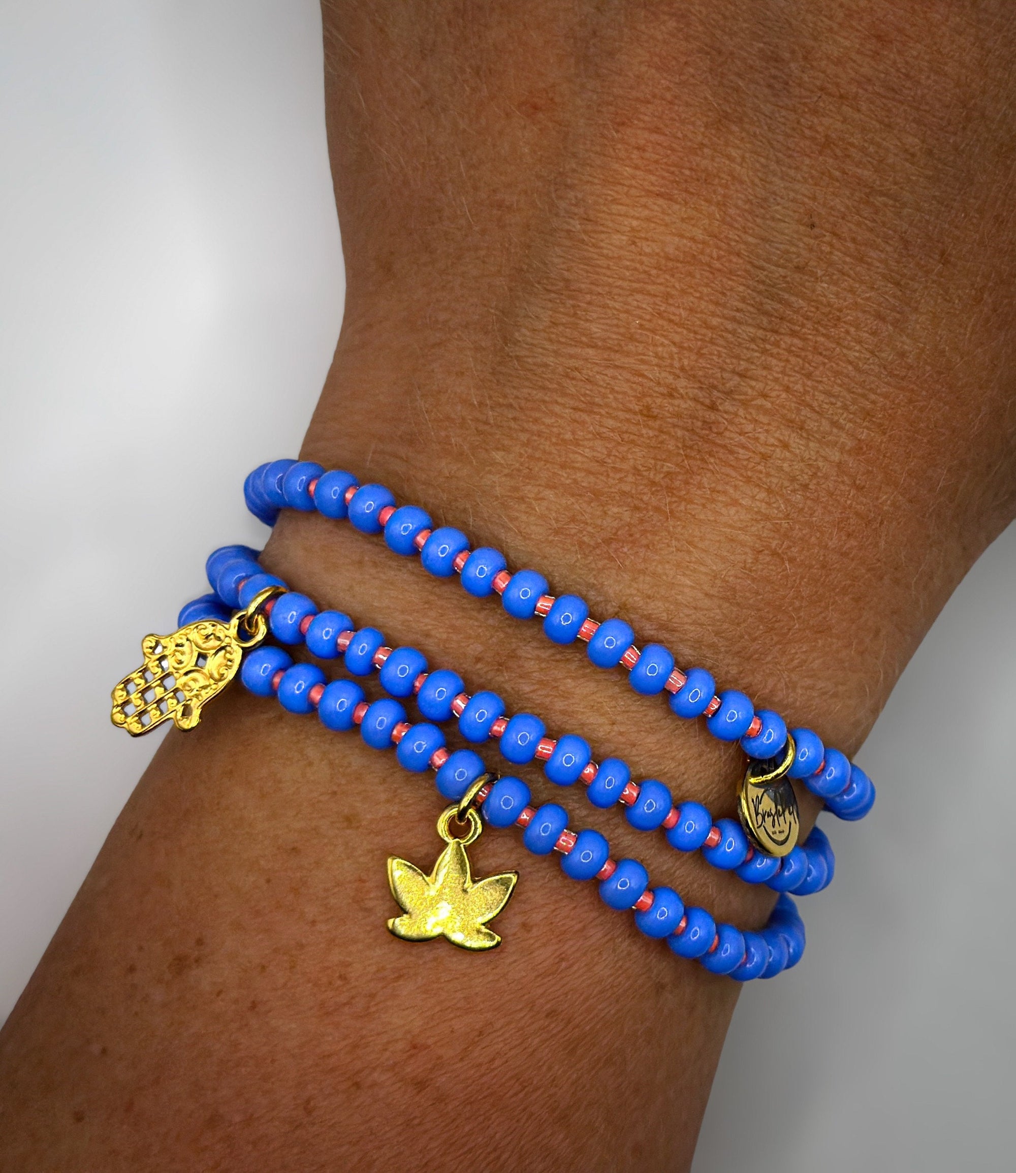 Armband aus Glas-Rocailles in blau und orange mit Fatimas Hand-Anhänger und Lotusblüte