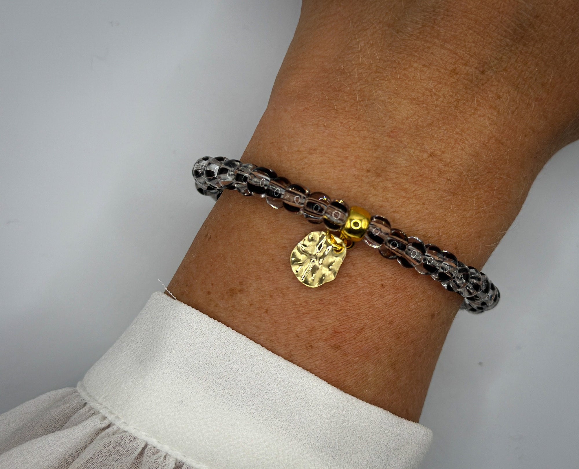 Armband aus Glasrocailles und goldenem Anhänger